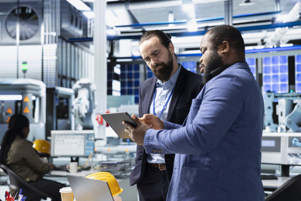 Multiethnic specialists engineers doing teamwork on modern production line